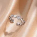 Close-up of silver-tone open ring featuring alternating polished and paved crystal heart charms. - Linked Heart Pattern Style (JZ2940P-6)