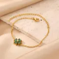 Close-up detail of the 18K gold plated stainless steel green clover bracelet pendant. - Green