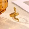Detail shot of a golden snake ring on textured surface, minimalist fashion jewelry design. - Snake Open Style (JZ9654G)