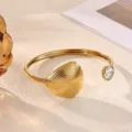 Detailed shot of gold-plated open bracelet with sparkling diamond accent and unique texture. - Geometric Textured 3D Style (B2272G)