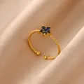 Close-up detail of a charming 18k gold plated stainless steel blue cubic zirconia flower ring. - Open Ring / Blue