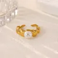 Gold plated stainless steel geometric open ring with central pearl and crystal detail. - Artificial Pearl Twisted Style (JZ9969G)