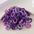 Close-up detail of seamless purple hair ties in a tray, soft elastic bands for girls styling. - 100 Pieces/Pack / Mixed Colors H