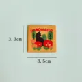 Handmade fabric woven label detail featuring cute black cat and floral embroidery patch. - Flower Cluster (Yellow Background)