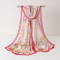 Vue détaillée d'écharpe en mousseline légère avec imprimé floral et bordure rouge. - Écharpes en mousseline de gaze 8