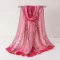 Détail de l'écharpe en mousseline à fleurs roses suspendue sur une barre montrant le beau motif. - Écharpes en mousseline 20