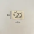 Detail shot of a cute cotton clothing label featuring a dog illustration and letters. - Korean Style Dog