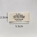 Close-up detail of minimalist handmade fabric label with floral design and dimensions. - Original Design Style (md104)
