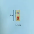 Etichetta in tessuto con ricamo floreale e fiocco, vista dettagliata per accessori di abbigliamento. - Giallo