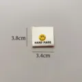 Detail view of the cotton handmade smiley face woven fabric label clothing accessories tag. - Smiley Cloth Label (sy155)