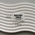 Close-up detail shot of white woven clothing label featuring stylish black text design. - Rostory Small Size