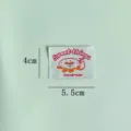 Close up detail of cute donut embroidery patch, handmade woven label for garment decor. - Donut Woven Label