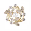 Elegant gold butterfly brooch with shimmering rhinestones and a central pearl for women. - Gold