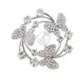 Elegant silver tone butterfly brooch featuring sparkling rhinestones and a central white pearl accessory. - Silver