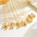Gold bubble letter pendant necklace detail shot featuring sparkling cubic zirconia stones. - Necklace B