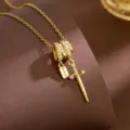 Gold-plated necklace featuring a detailed dagger pendant and sparkling zirconia stones. - Dagger Style (T2318)