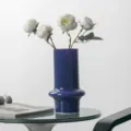 Detail view of a vintage dark blue glass vase with white artificial roses on a glass table. - Soft Jade — Dark Night Purple Grade A