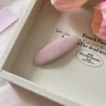 Close-up of a sweet pink fabric oval BB hair clip styled in a beige tray with pink tulips. - Oval / Light Pink