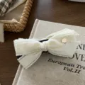 White bow hair clip detail view, elegant fabric hair claw featuring a delicate gold heart accent for women. - Banana Clip