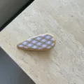 Vista dettagliata di un elegante fermaglio per capelli in acetato con motivo a losanghe. - Fermaglio Anatra Quadri Giallo