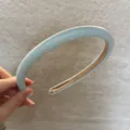 Gros plan du serre-tête en cuir crème, montrant la texture lisse et la finition soignée. - Bleu