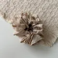 Primer plano detallado de un coletero de satén plisado beige con tela suave de doble capa. - Blanco Roto