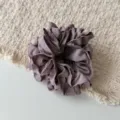 Detalle de coletero de satén plisado en morado polvoriento, accesorio elegante para el pelo. - Rosa Púrpura