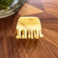 Detailed shot of a stylish marble acetate hair claw clip, elegant cream tone for daily updos. - Beige