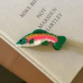 Gros plan détaillé d'une pince à cheveux unique en acétate en forme de poisson coloré. - Truite Verte