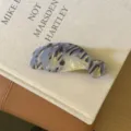 Jolie pince à cheveux en acétate lamantin, motif gris détaillé et design doré chic. - Phocidé