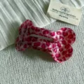 Primo piano di un fermaglio per capelli a forma di osso leopardato rosa, acetato, elegante. - Pinza a Osso Grande / Stampa Leopardata Rosa