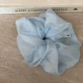 Detailansicht eines hellblauen Organza Haargummis, weiche Mesh-Struktur für elegantes Styling. - Blau