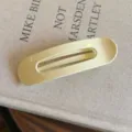 Pince à cheveux ovale jaune clair minimaliste, détail en gros plan, accessoire de coiffure uni. - L / Jaune