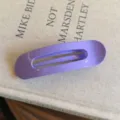 Détail de pince à cheveux ovale violette avec une surface brillante effet bonbon. - L / Violet