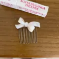 Detail view of the elegant white pearlescent bow hair comb with metal teeth for women styling. - Mermaid White