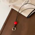 Cordón de cuero negro para gafas con cuenta roja y anillo de metal para accesorios. - Cuentas Rojas