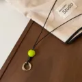 Vista de detalle de cordón de gafas de cuero negro con cuenta verde y anillo. - Cuenta Verde