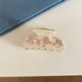 Vue détaillée d'une élégante pince à cheveux en acétate avec des fleurs roses et strass. - Style Floral Papillon Rose