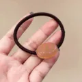 Detailopname van schattige ovale haarelastiek met roze stippen en hoge elasticiteit. - Nude Roze Doorschijnend