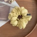 Vista de detalle coletero de gasa amarilla, diseño suave plisado con pequeña etiqueta tejida. - Amarillo