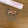 Close-up detail of a fashionable tortoiseshell bow hair comb featuring durable metallic teeth. - Light Leopard
