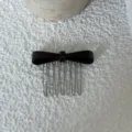 Detailed view of elegant acetate bow hair comb, stylish hair accessory for women styling. - Black