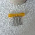 Close-up of yellow acetate bow hair comb with metallic teeth, detail shot of hair accessory. - Yellow