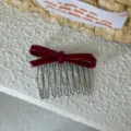 Vista detallada de peine para el pelo con lazo rojo, elegante accesorio de acetato con dientes. - Rojo