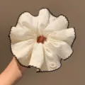 Detailed view of large white hair scrunchie featuring black lace trim and bow accent. - Classic Scrunchie Style / White