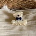 Detail view of the cute acetate bear hair claw clip featuring a blue bow tie and marbled texture. - Off White