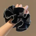 Zwarte sateen haarelastiek met witte contraststiksels, zachte en stijlvolle haardecoratie. - Getailleerde Ruffle Stijl / Zwarte Getailleerde Stijl