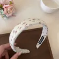 Gros plan détaillé du serre-tête floral doux, accessoire en tissu blanc, design délicat. - Blanc Cassé