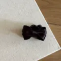 Black satin bow hair claw clip detail, elegant hair accessory for styling and pinning. - Black