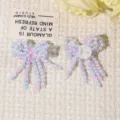Detailed close-up shot of handmade beaded bow patch, sparkling crystal fringe, DIY acc. - Blue Pink
